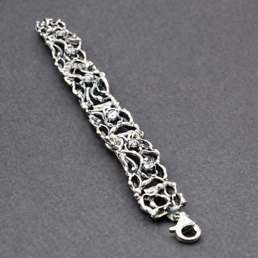 Il bracciale disteso su fondo grigio, con il moschettone in basso