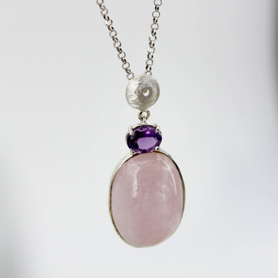 Il pendente appeso alla catena su fondo chiaro: sfera d'argento, ametista e morganite in fila