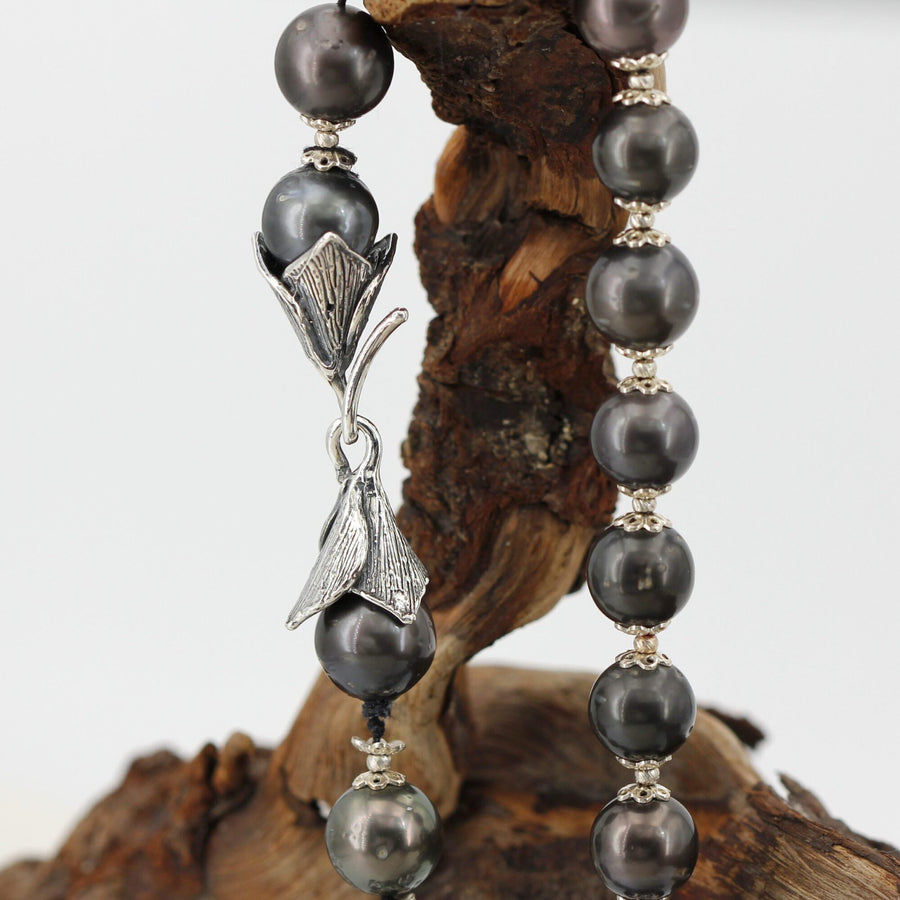 The clasp in profile: each leaf closes like a cup over the end pearl