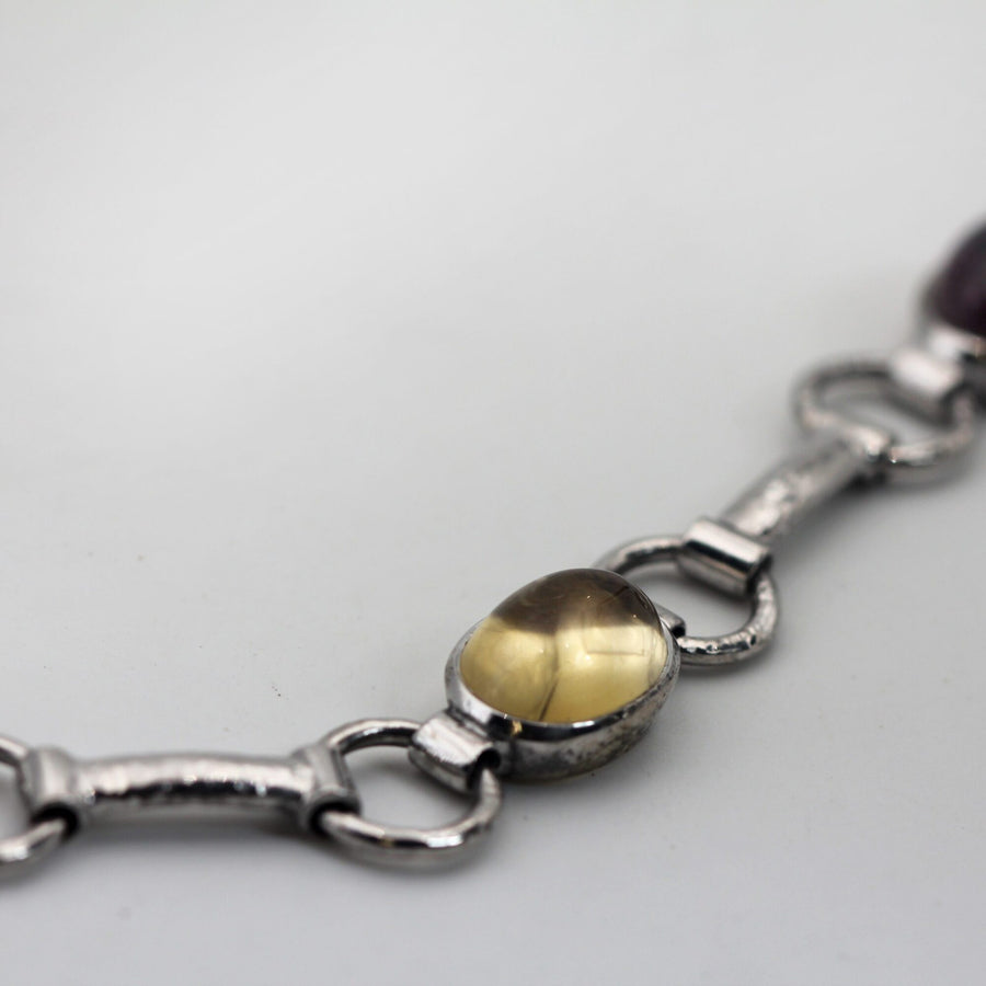 Un cabochon giallo e la barretta battuta a martello che lo collega all'anello successivo