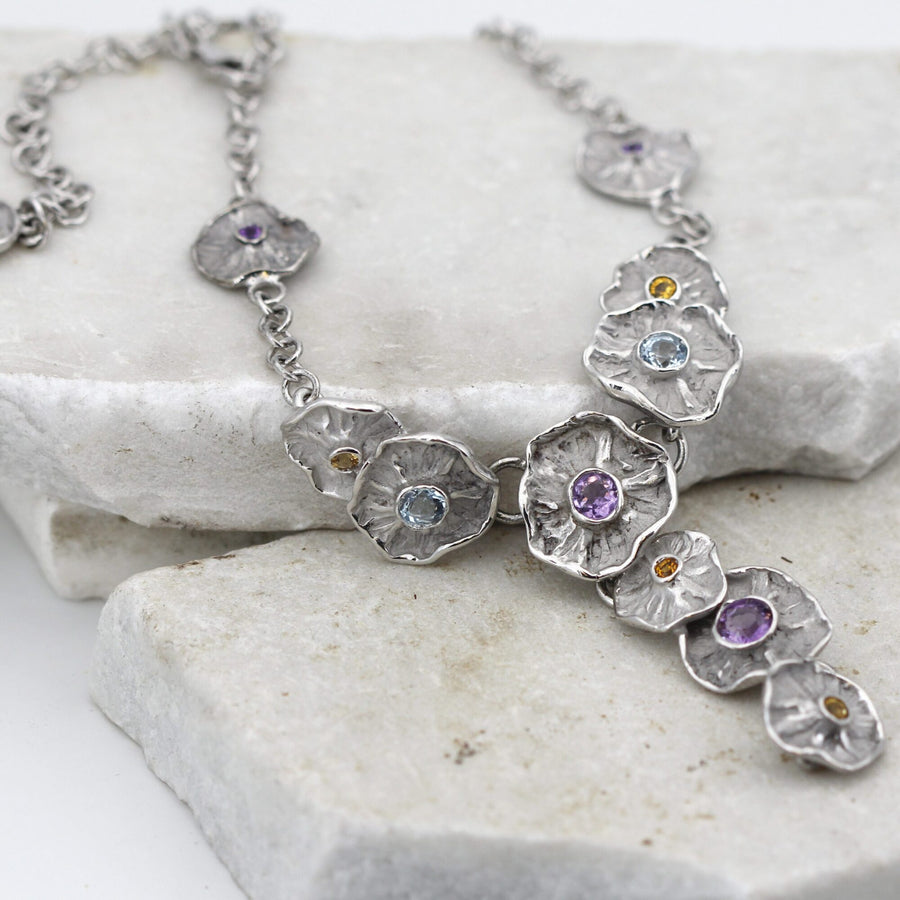 The necklace laid out: the round-link chain, the single flower on one side and the clasp at the top