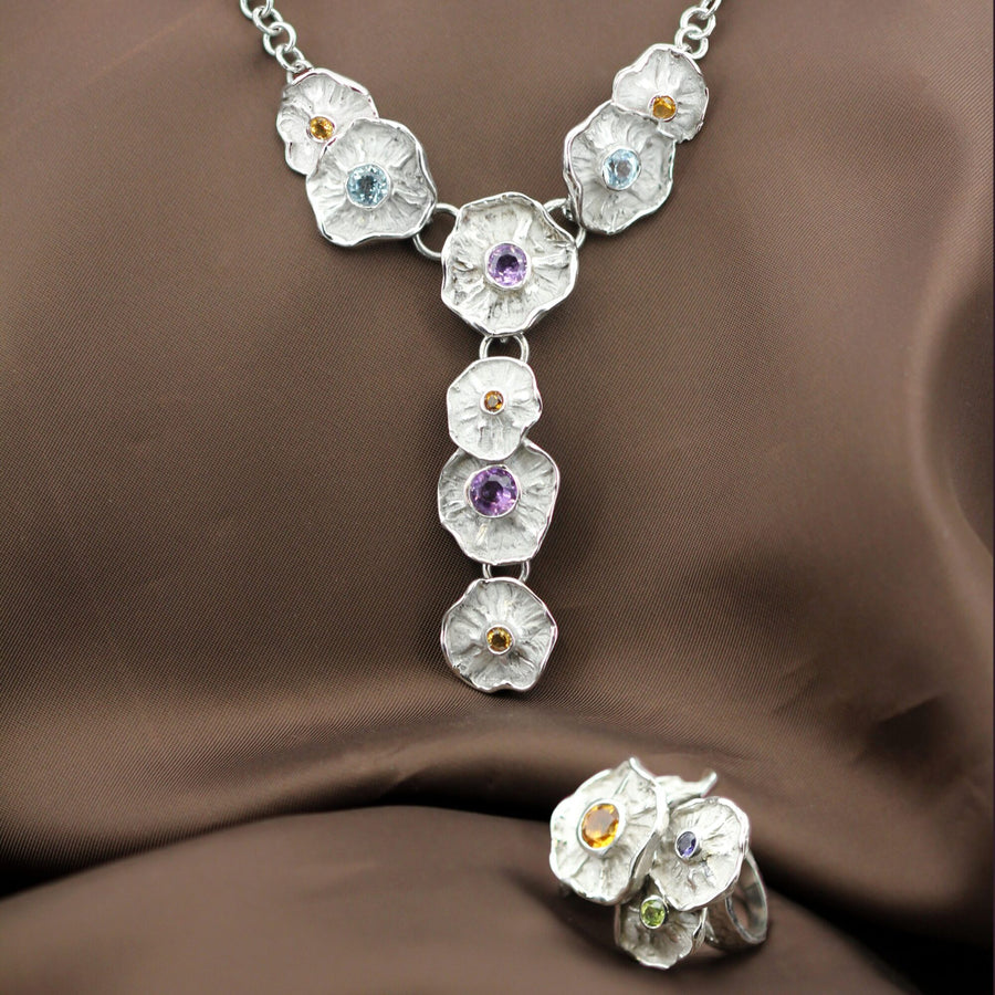 The necklace on dark silk; the ring that appears at the bottom is not included in the price