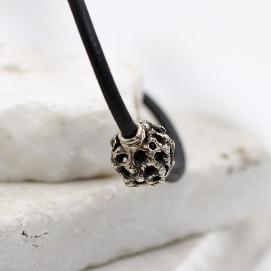 The point where the leather enters the sphere, held by the silver washer