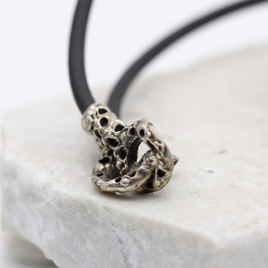 The hook clasp fastened, resting on the edge of a stone