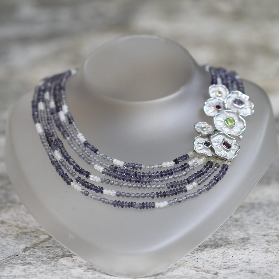The necklace seen from the front: the alternation between the purple beads of iolite and the white ones of labradorite can be read
