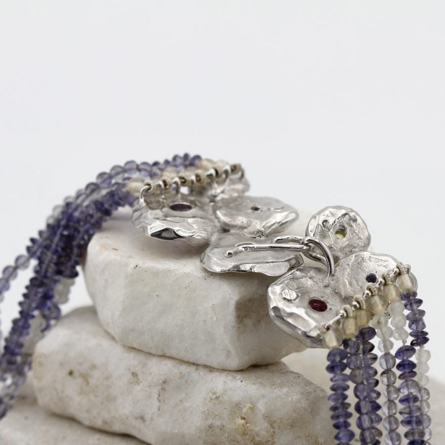 The back of the clasp: the silver hook fastened to the ring, and the ends of the strands wound onto the small rings