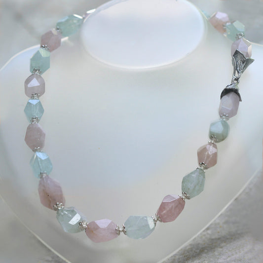 La collana chiusa a cerchio su un busto bianco, con la sequenza alternata di pietre rosa e verde acqua