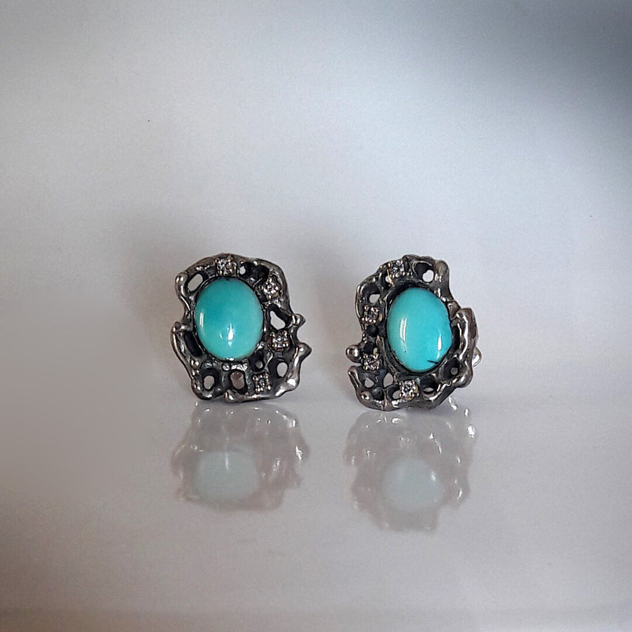The pair standing on the polished surface, with the reflection beneath: the jagged outline of the pierced silver can be read