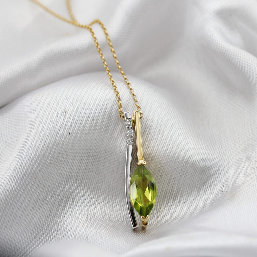The marquise peridot held at its two points by the yellow gold prongs