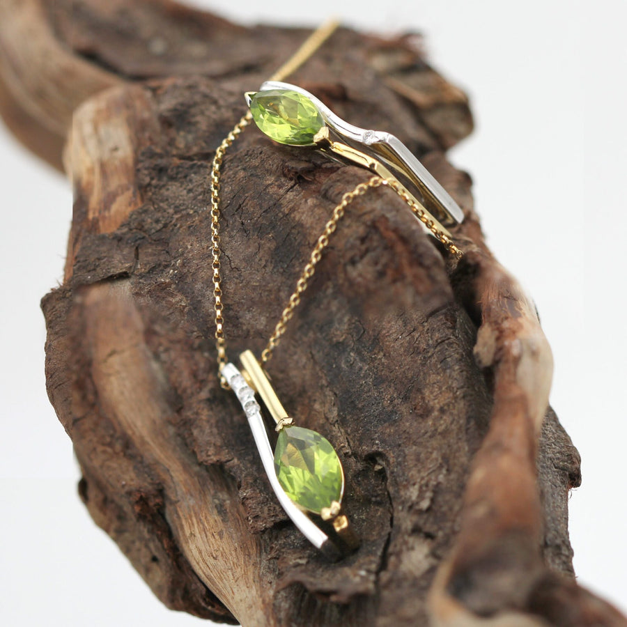 Pendant and ring from the same set resting on a piece of wood