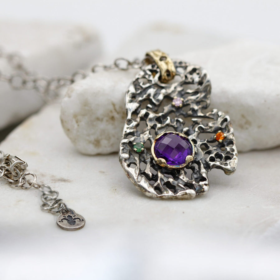 The pendant next to the clasp of the chain, with the small round tag