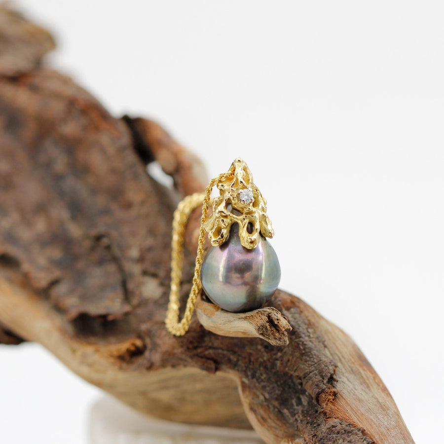 The drop of the pearl resting on the wood, with the chain gathered (not included)