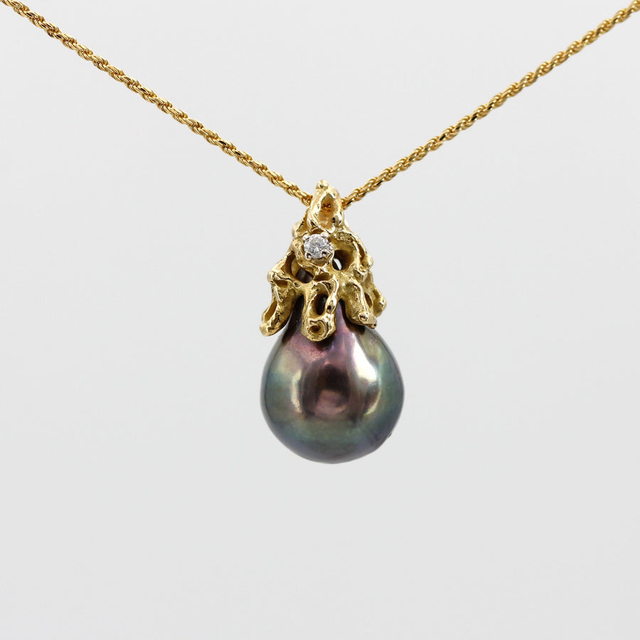 Close-up on the chain: the aubergine reflection at the centre of the pearl