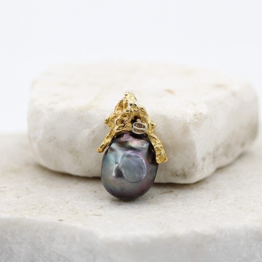 The pendant from behind: the seat of the diamond from the reverse and the hollow on the body of the pearl