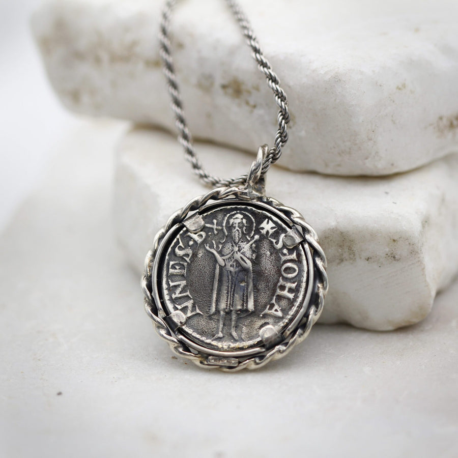 Il retro del pendente: san Giovanni Battista in piedi e le quattro linguette che trattengono la moneta