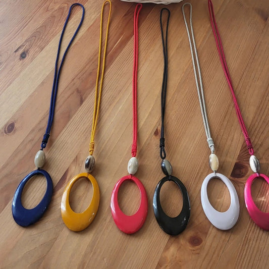 Sei ciondoli ovali su cordino intrecciato, uno per colore: blu, senape, rosso, nero, bianco e fucsia