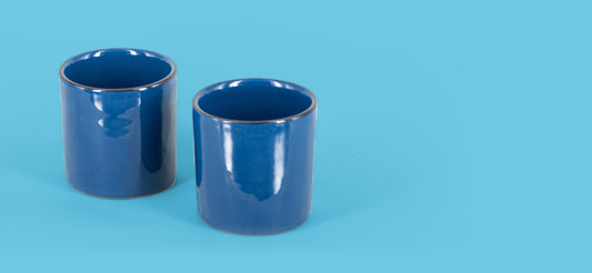 Due bicchieri blu mare affiancati sul fondo azzurro del catalogo