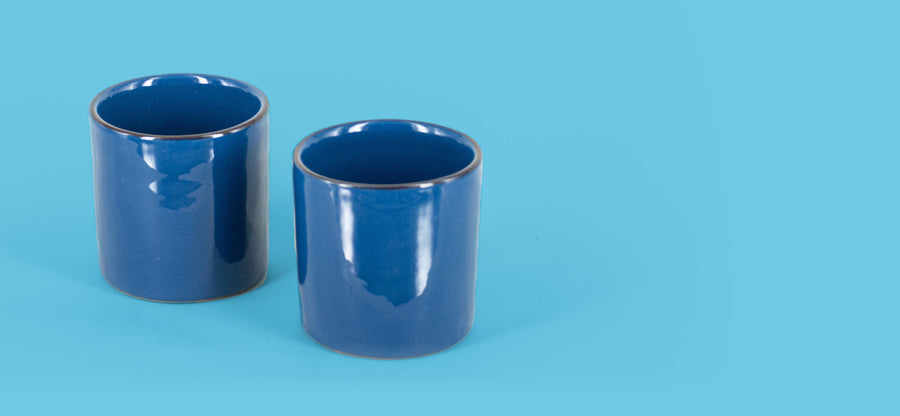 Due bicchieri blu mare affiancati sul fondo azzurro del catalogo