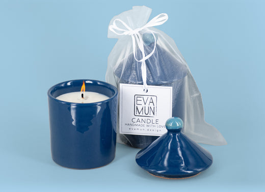 Candela accesa in un vaso di maiolica blu mare, con il coperchio dal pomello azzurro