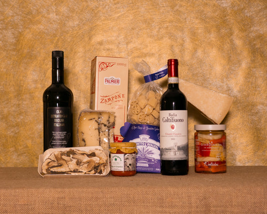 I 10 prodotti del cesto «Capolavoro Enogastronomico» disposti sul fondo di juta, fra cui Zampone Palmieri, Chianti Classico DOCG Badia a Coltibuono e Ruote Pastificio Benedetto Cavalieri, e gli altri.