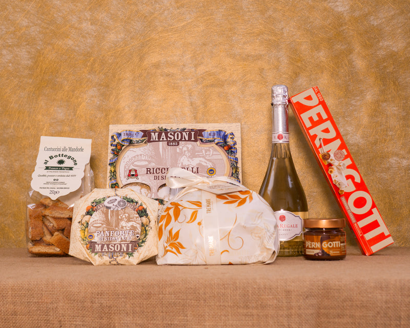 I 7 prodotti del cesto «Dolce Natale» disposti sul fondo di juta, fra cui Pandoro Tre Marie, Asti DOCG Rosa Regale Banfi e Ricciarelli di Siena IGP Masoni, e gli altri.