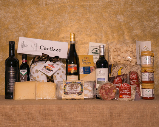 I 24 prodotti del cesto «Gran Natale Italiano» disposti sul fondo di juta, fra cui Le Volte dell’Ornellaia 2023, Moscato a tappo raso La Gatta e Valdobbiadene di Cartizze Superiore Andreola, e gli altri.