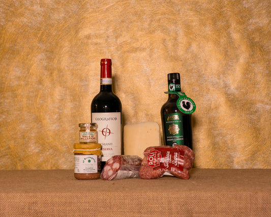 I 7 prodotti del cesto «Merenda Toscana» disposti sul fondo di juta, fra cui Chianti Riserva DOCG Geografico, Salame Toscano e Salsicce di Siena stagionate Poli, e gli altri.