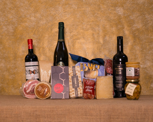 I 14 prodotti del cesto «Scrigno delle Feste» disposti sul fondo di juta, fra cui Valdobbiadene Extra Dry Bellussì, Bolgheri DOC Rosso diVaira e Panettone artigianale Biffi, e gli altri.