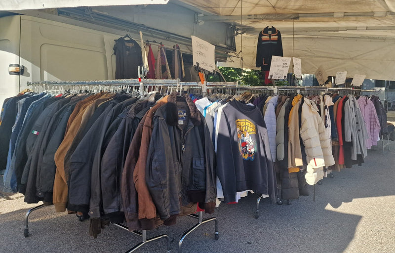 La fila di giubbotti in pelle e giacche appesi sotto il tendone