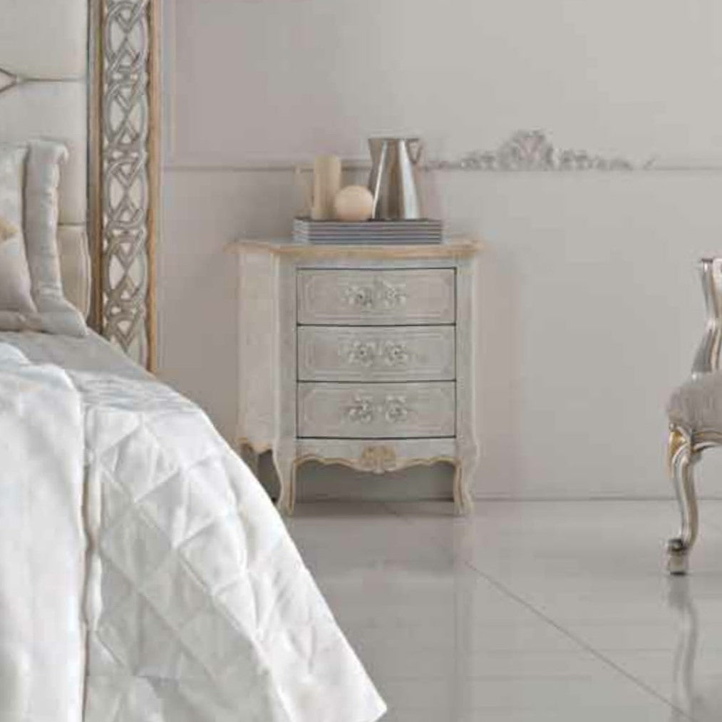 The 535 bedside table next to the bed: the bowed front with the three painted drawers and the carved apron under the top