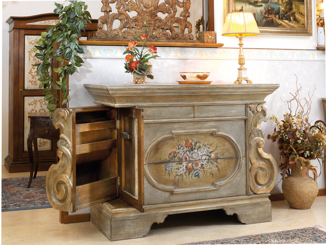 La credenza 630 con un fianco aperto: l'ovale dipinto sul fronte, le volute laterali e i ripiani che compaiono nel fianco