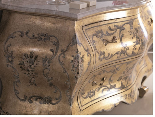 Il fianco e lo spigolo da vicino: le cartelle dipinte sull'oro e il bordo sagomato del piano in marmo
