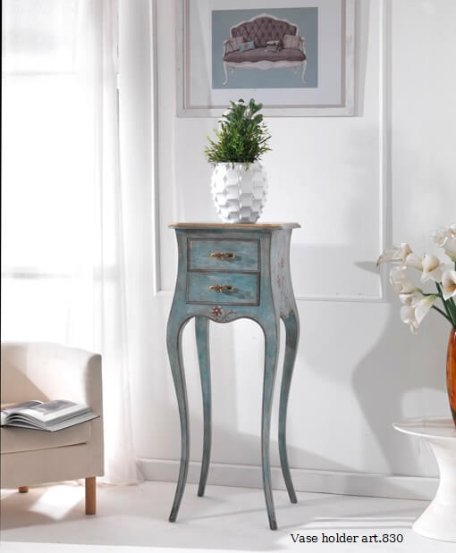 Il portavaso 830 davanti a una finestra: il corpo blu con i due cassetti e le quattro gambe lunghe e curve