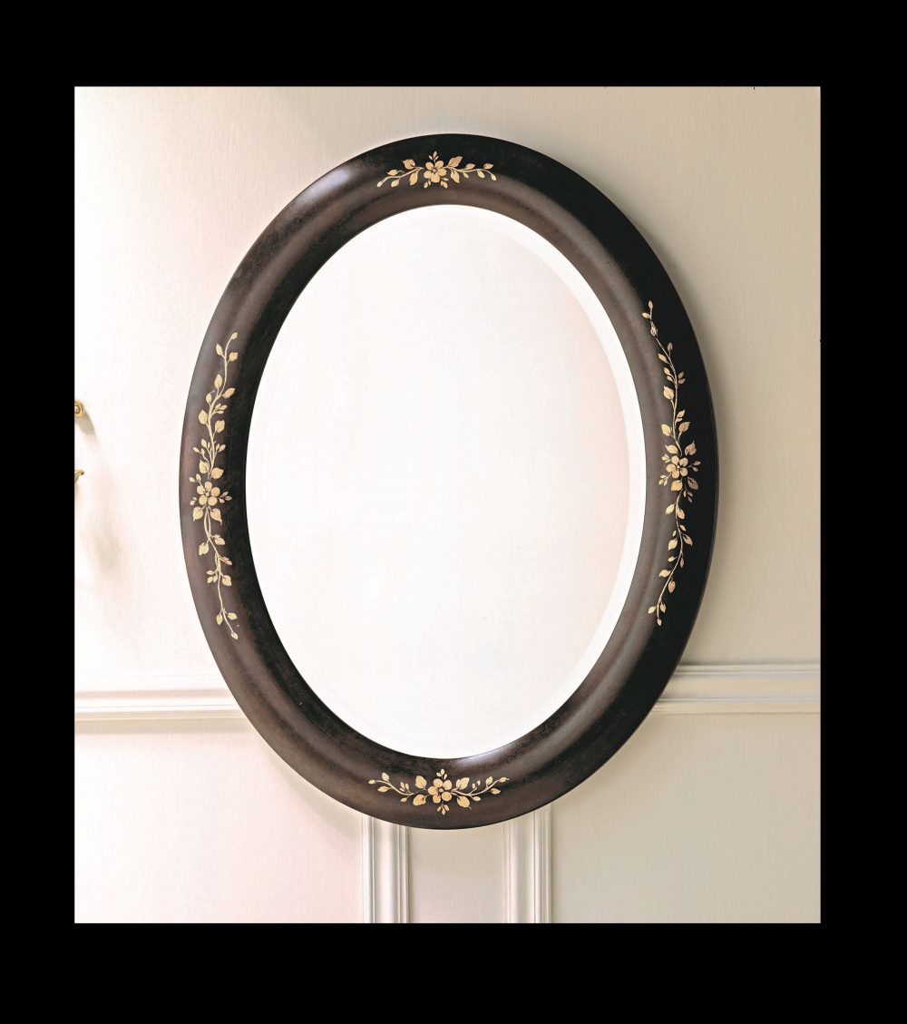 The oval 1577 mirror: the mocha-lacquered cove and the small bunches of flowers painted in gold