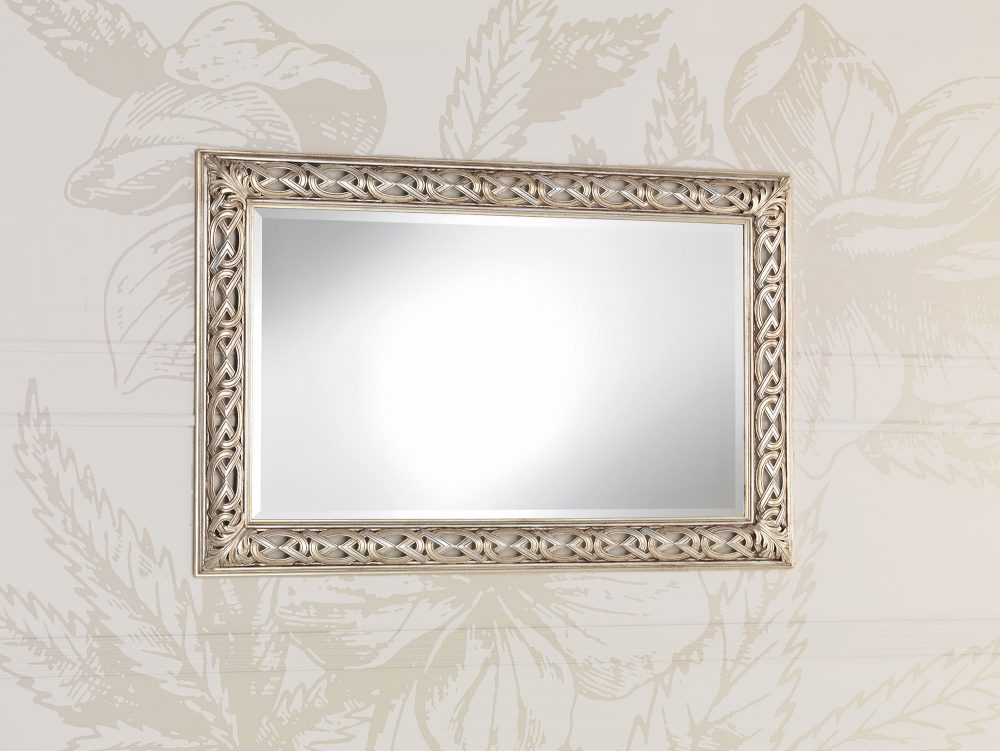The 1588 wall mirror: the openwork ribbon of scrolls that lets the wall show through between the solid parts