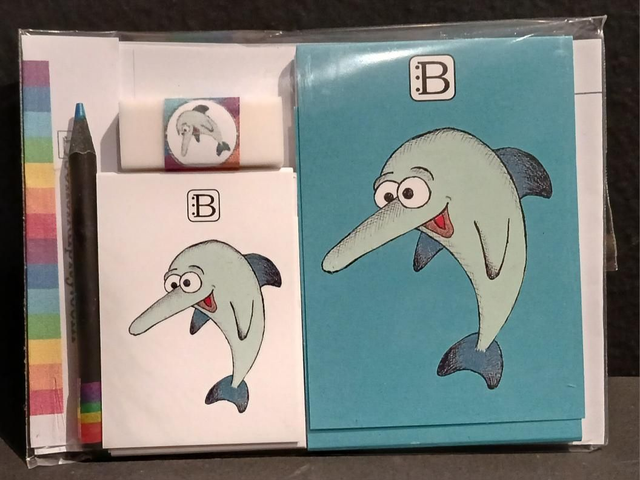 Il kit Leggi & Colora dedicato al Delfino, chiuso nella busta: i due taccuini, la matita, il righello e la gomma