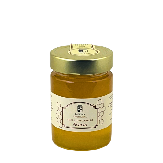 Vasetto di miele toscano di acacia della Fattoria Uccelliera, miele chiaro e limpido, su fondo bianco