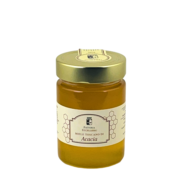 Vasetto di miele toscano di acacia della Fattoria Uccelliera, miele chiaro e limpido, su fondo bianco