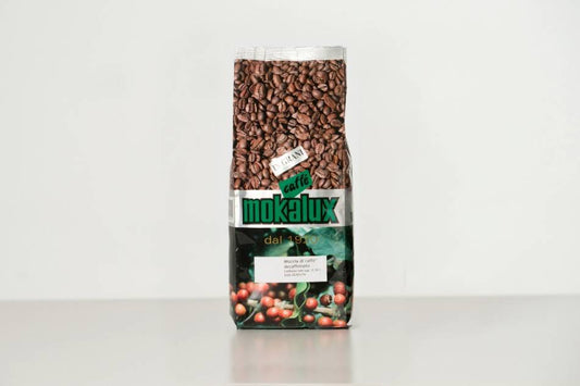 Il pacco del decaffeinato Mokalux, con i chicchi in vista dietro la finestra