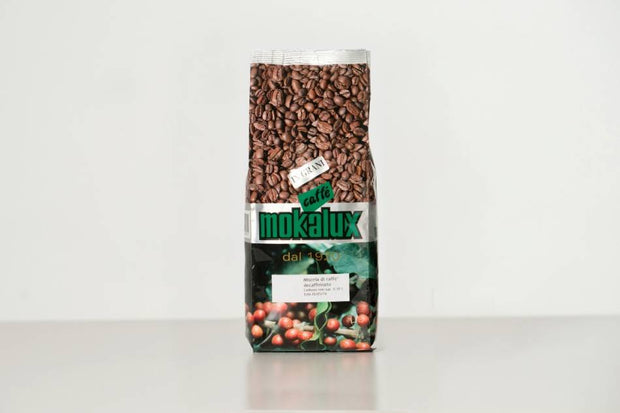 Il pacco del decaffeinato Mokalux, con i chicchi in vista dietro la finestra