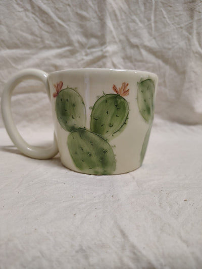 Tazza con le pale del fico d'India e i fiori aranciati