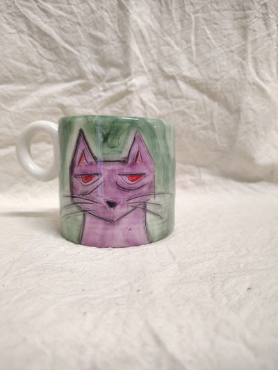 Tazza con un gatto rosa su fondo verde spennellato