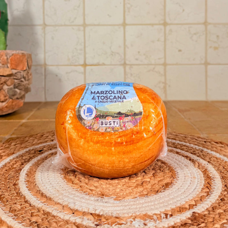 La forma ovale del marzolino con la crosta rossa e l'etichetta a caglio vegetale