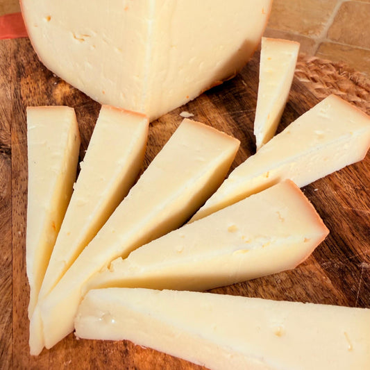 La forma tagliata e le fette disposte a ventaglio sul tagliere, con la pasta elastica in vista
