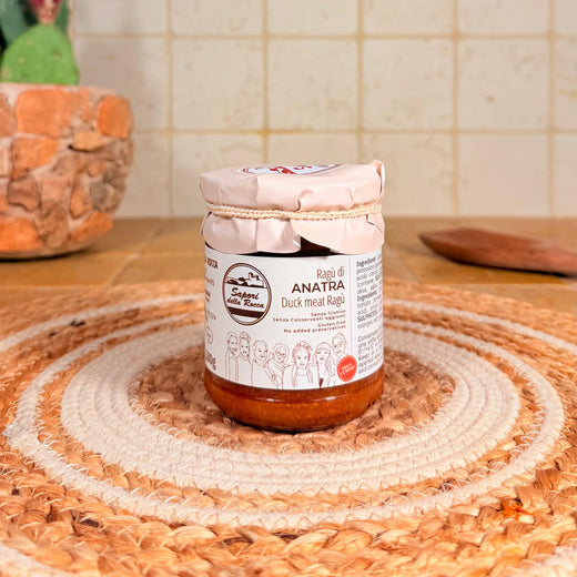 Il vasetto di Ragù d'anatra con l'etichetta chiara, sul centrino all'uncinetto