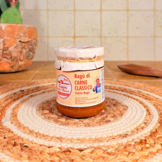 Il vasetto di Ragù di carne classico con la fascetta di stoffa sul coperchio, su un centrino all'uncinetto
